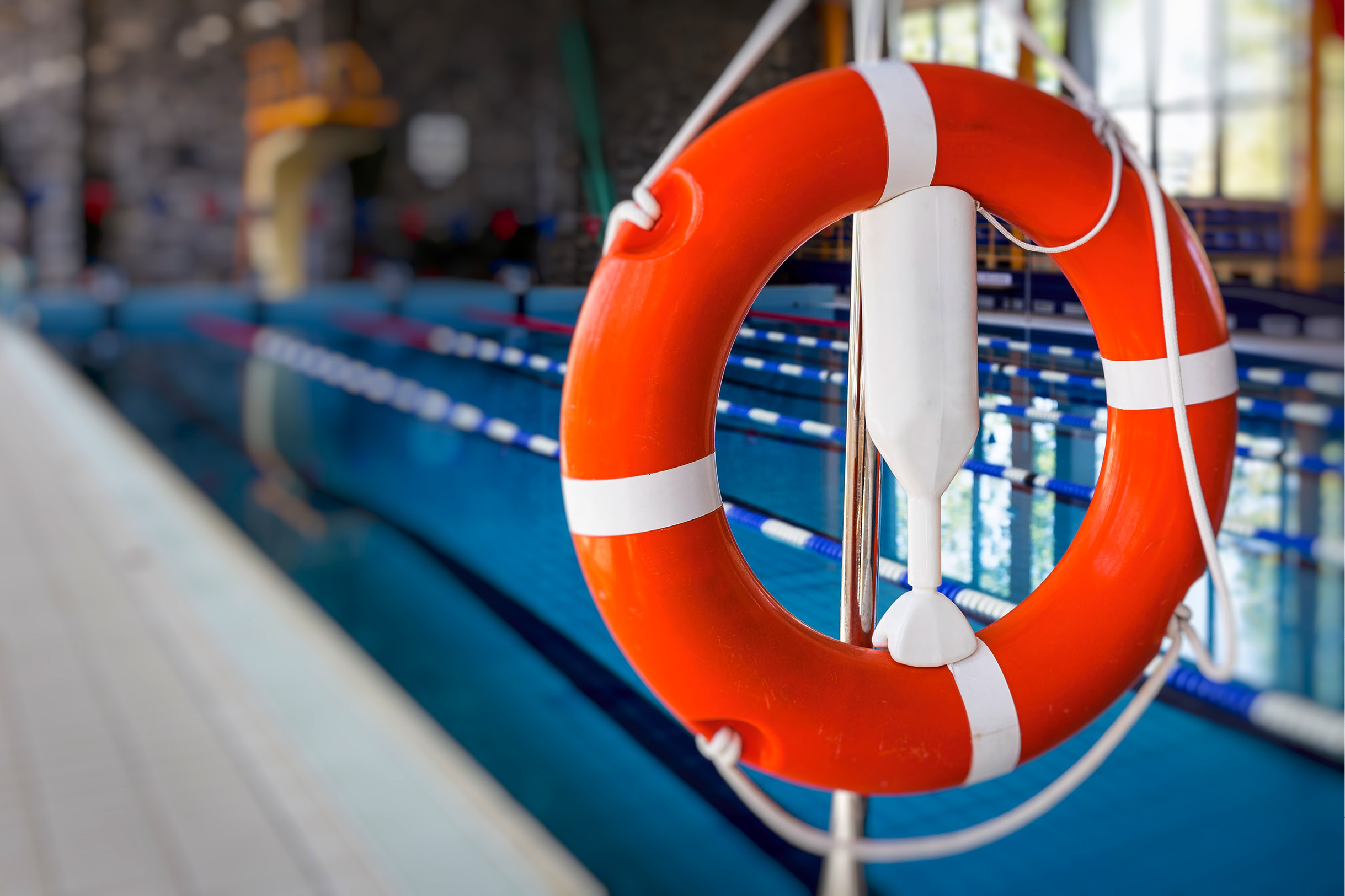 Ein Rettungsring hängt griffbereit am Rand eines Schwimmbeckens.