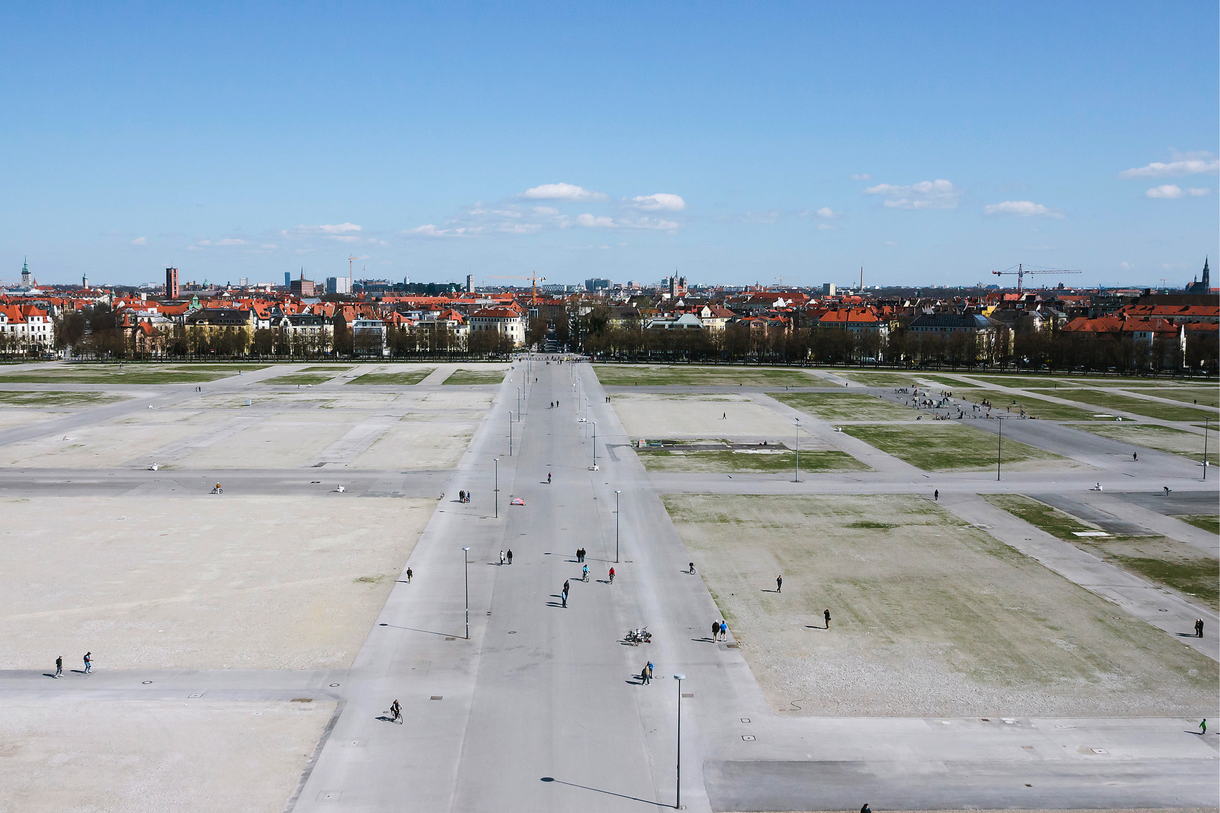 Einige Münchener spazieren über die leere Theresienwiese.