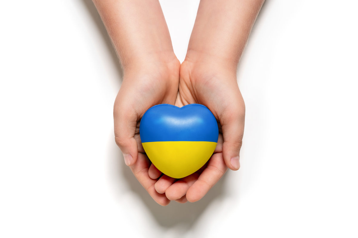 Ein Herz in den ukrainischen Farben wird in den Händen gehalten