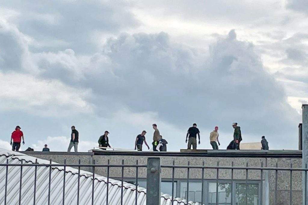 Menschen auf dem Dach einer Werkshalle